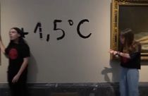 Les deux militantes au musée du Prado à Madrid avec l'inscription "+1,5°C" derrière elle en référence au réchauffement maximal que s'est fixé la communauté internationale.