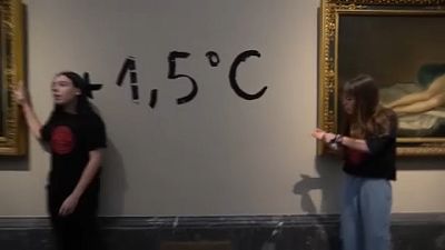 Les deux militantes au musée du Prado à Madrid avec l'inscription "+1,5°C" derrière elle en référence au réchauffement maximal que s'est fixé la communauté internationale.