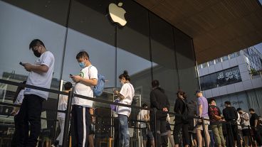 Customers line up outside of an Apple Store before its opening on the first day of sale for the Apple iPhone 14 in Beijing, China.