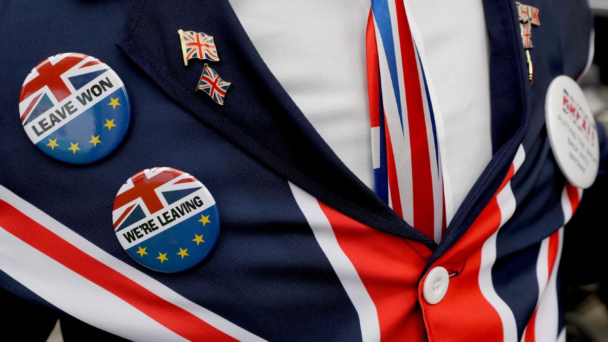 A pro-Brexit supporter wears badges as he demonstrates outside Parliament in London, Oct. 28, 2019. 