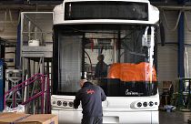 Technikusok dolgoznak egy hidrogén-üzemű busz összeszerelésén