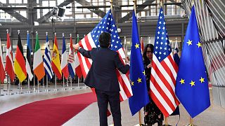A member of protocol puts up the European Union and U.S. flags prior to the arrival of U.S. President Joe Biden for an EU summit in Brussels, Thursday, March 24, 2022.