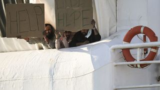 Мигранты на судне Geo Barents держат плакаты с надписью "Помогите!". Катания, Италия. 7 ноября 2022.