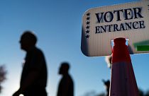 Voters pass a sign outside a polling site in Warwick, R.I., Monday, Nov. 7, 2022, after casting their ballots on the last day of early voting before the midterm election.