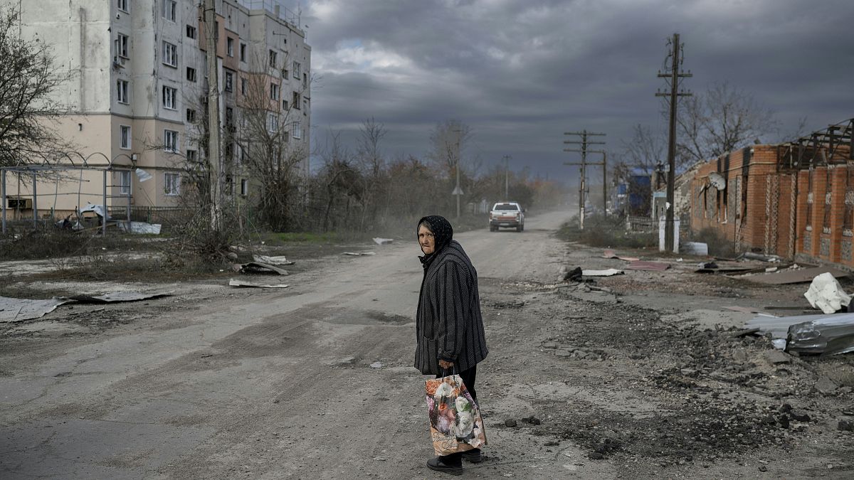 Жительница поселка Архангельское, Херсонской области на фоне разрушенных домов