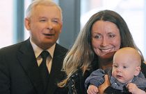 A woman and baby stand near Jaroslaw Kaczynski during a presidential election campaign in 2010.