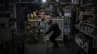 A camping light illuminates a souvenir shop during a power outage in downtown Kyiv