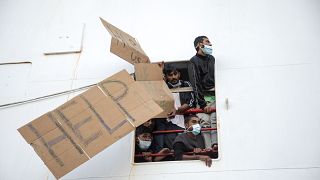 Migrants show placards demanding the disembark for all as the wait aboard of the Norway-flagged Geo Barents rescue ship , in Catania's port, Sicily, southern Italy, Nov 8 2022
