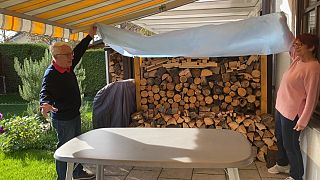 Das Ehepaar Möller zeigt das Holz, das zum Heizen ihres neuen Kamins schon bereitliegt.