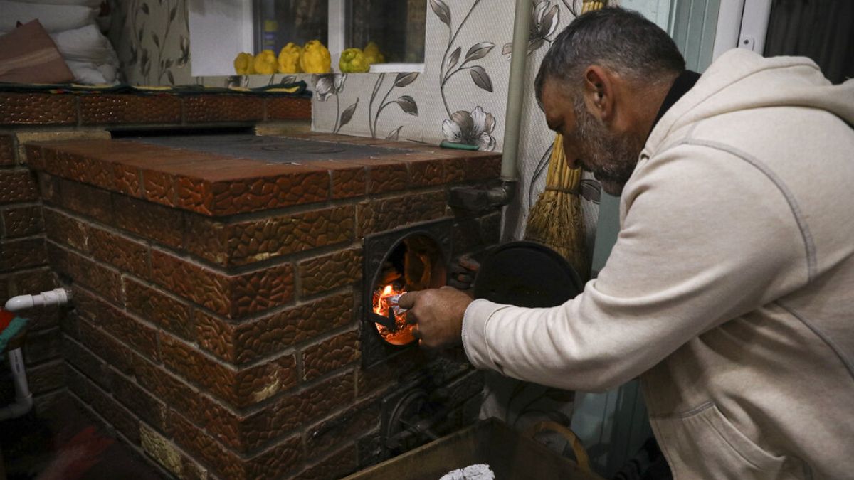 Un hombre enciende una horno de leña en Moldavia. 
