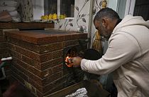 Un hombre enciende una horno de leña en Moldavia.