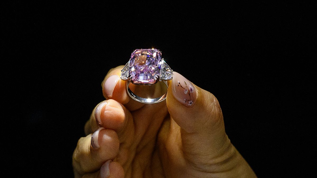سيدة تعرض خاتم ساكورا دايموند وردي اللون، خلال معاينة مزاد كريستيز في هونغ كونغ، الصين. 