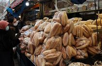 Women shop for bread at a market in Ankara - December 2021