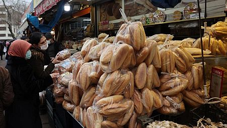 Women shop for bread at a market in Ankara - December 2021
