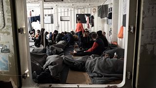 Migrants are wrapped with blankets as they gather on the deck of the Ocean Viking rescue ship, in the Mediterranean Sea, near the coast of Sicily, southern Italy, Nov. 6, 2022