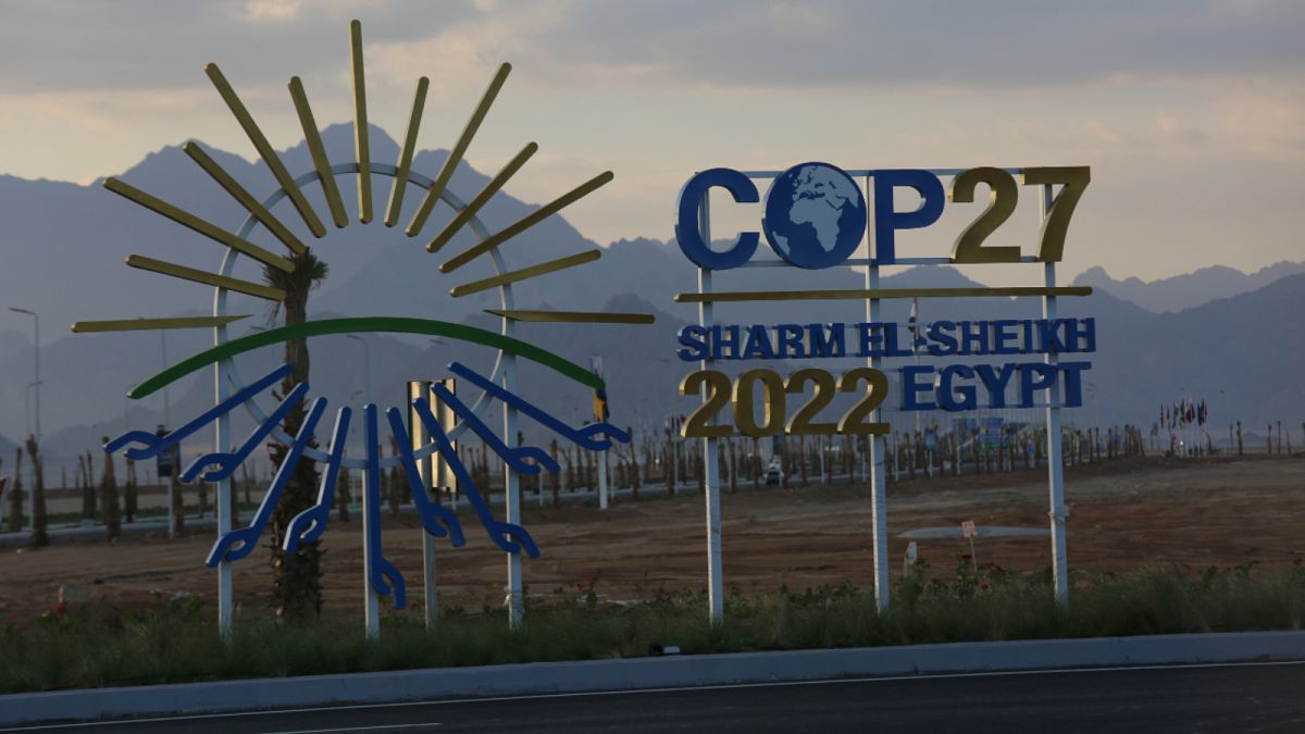 غروب الشمس خلف لافتات لقمة المناخ في شرم الشيخ 