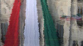 Magyar zászló tükröződik a Parlament előtt