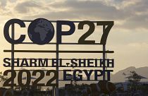 Coucher de soleil derrière les panneaux du Sommet des Nations Unies sur le climat COP27 à Sharm el-Sheikh, en Égypte, mercredi 9 novembre 2022.
