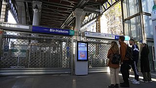 People stand in front of a closed subway station Thursday, Nov. 10, 2022 in Paris.