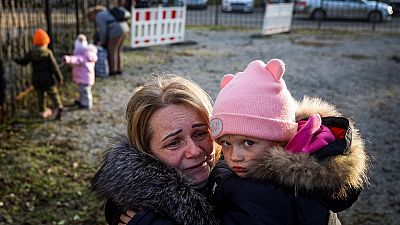Svetlana Titova, 52, hugs her granddaughter as they arrive from the Russian-held town of Berdyansk, November 7, 2022.