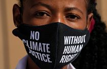 A woman wears a face mask that reads "no climate justice without human rights" during a silent protest for climate justice and human rights at COP27.