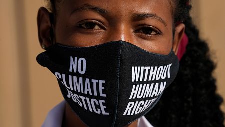 A woman wears a face mask that reads "no climate justice without human rights" during a silent protest for climate justice and human rights at COP27.