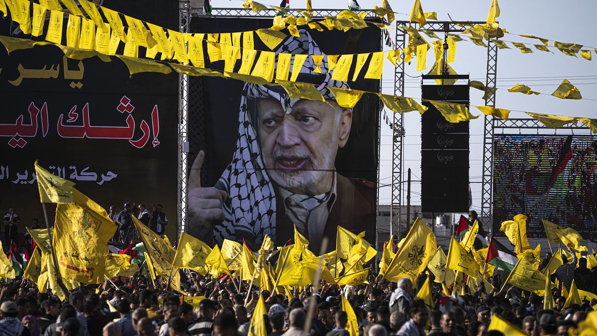 فلسطينيون يرددون يلوحون بأعلام حركة فتح خلال تجمع حاشد بمناسبة الذكرى الثامنة عشرة لوفاة ياسر عرفات