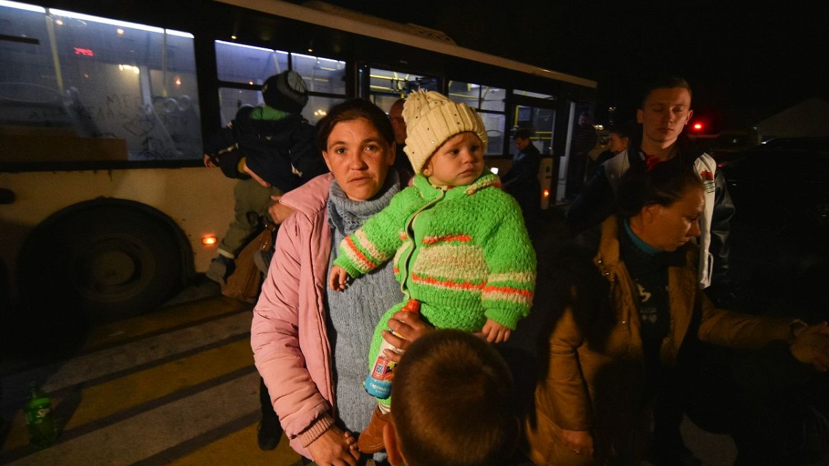 Evacuees from Kherson walk from a bus upon their arrival to Dzhankoi, Crimea, Thursday, Nov. 10, 2022.