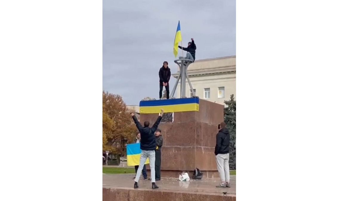 Habitants de Kherson brandissant des drapeaux ukrainiens sur la place de la Liberté à Kherson, le 11 novembre 2022