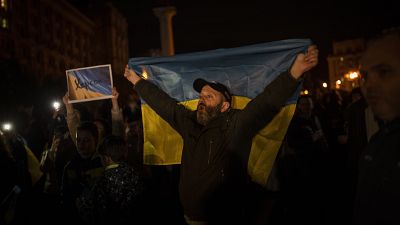 مواطن أوكراني يرفع علم بلاده محتفلاً بتحرير خيرسون
