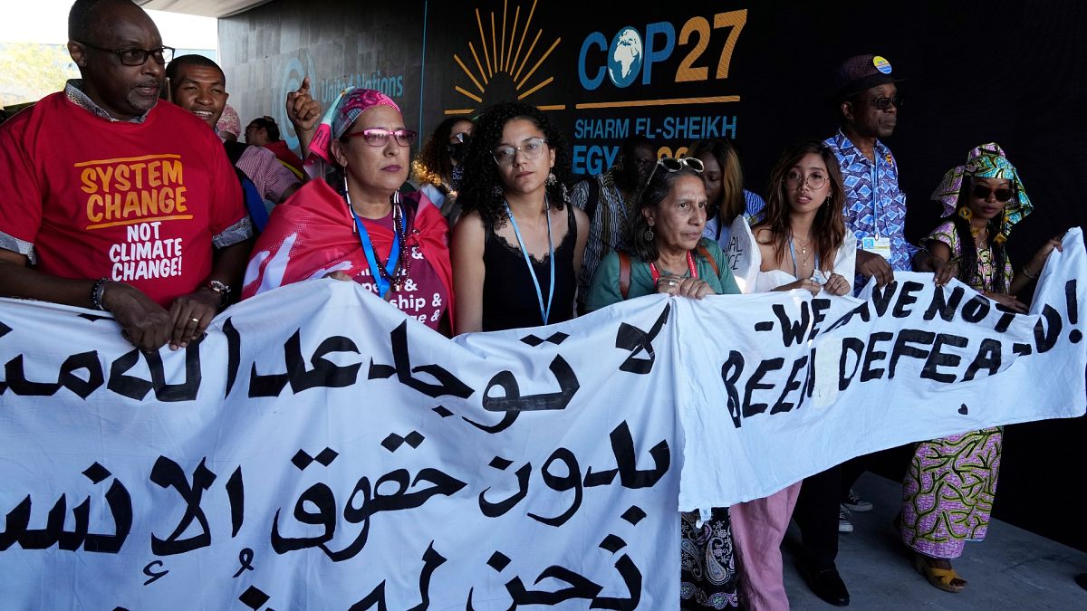 Sanaa Seif, center, sister of Egypt's jailed leading pro-democracy activist Alaa Abdel-Fattah, who is on a hunger and water strike, attends a protest with others at COP27.