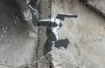 Une gymnaste en équilibre sur des gravats, l'œuvre de Banksy à Borodianka, en Ukraine.