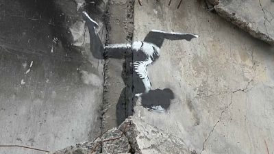 Une gymnaste en équilibre sur des gravats, l'œuvre de Banksy à Borodianka, en Ukraine.