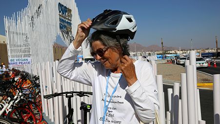 Dorothee Hildebrandt, 72, removes her bike helmet after arriving to the UN climate summit.