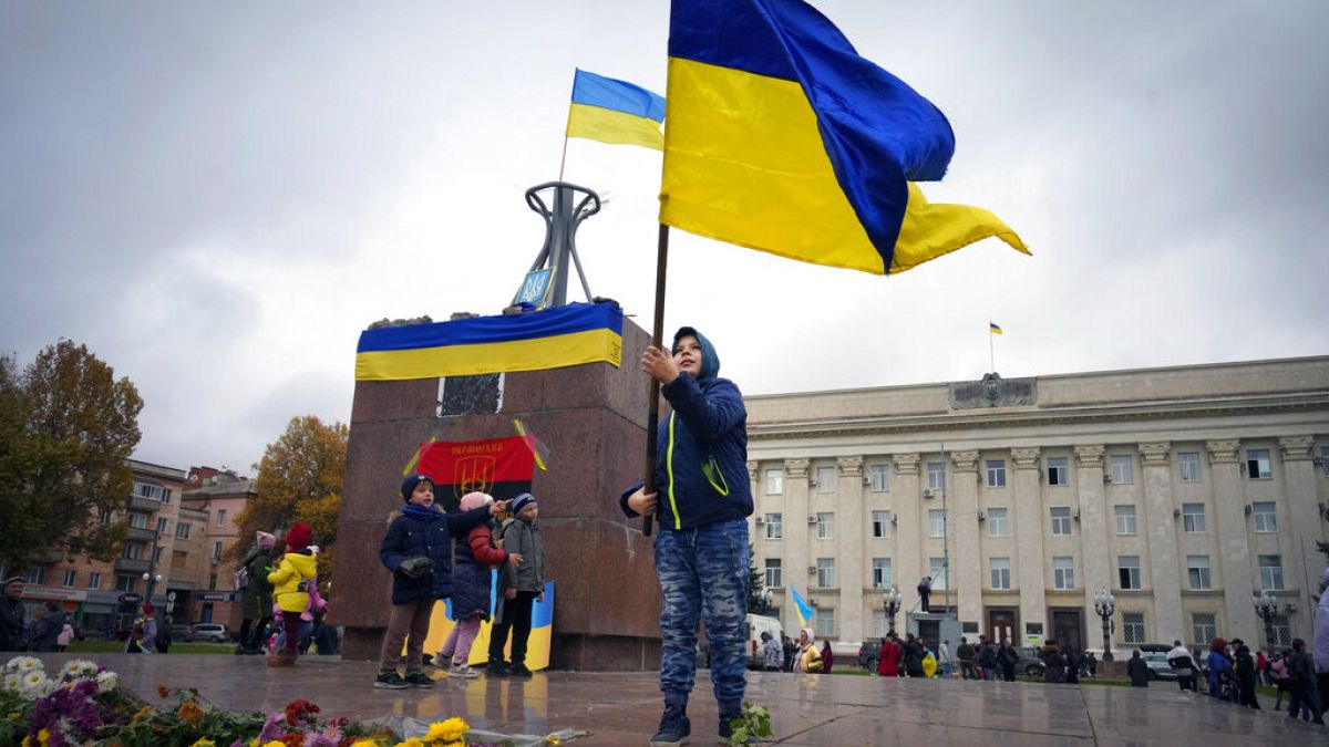 A boy holds a Ukrainian flag in central Kherson. 