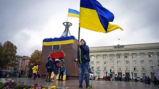 A boy holds a Ukrainian flag in central Kherson.