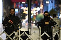 Police officers stand at the entrance the street after an explosion on Istanbul's popular pedestrian Istiklal Avenue, late Sunday, Nov. 13, 2022.