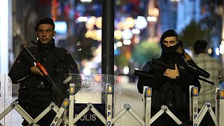 Police officers stand at the entrance the street after an explosion on Istanbul's popular pedestrian Istiklal Avenue, late Sunday, Nov. 13, 2022.