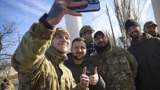 Ukrainian soldiers take a selfie with President Volodymyr Zelenskyy during his visit to Kherson.