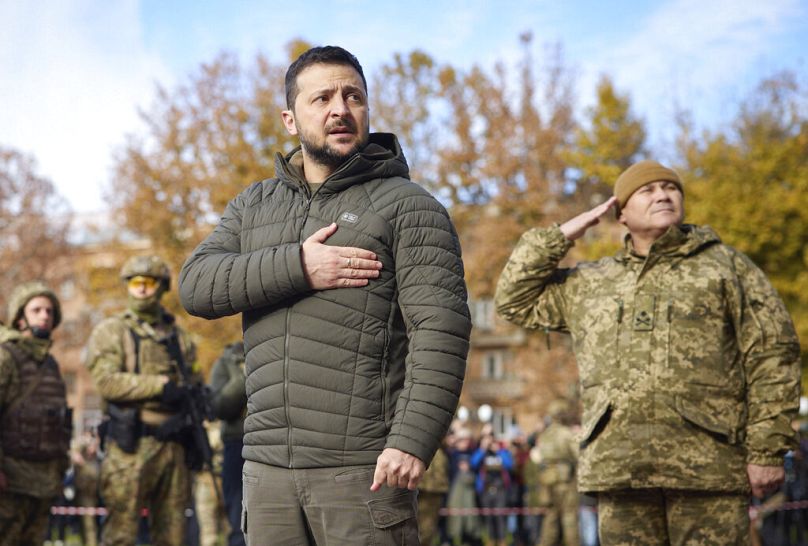 In this photo provided by the Ukrainian Presidential Press Office, Ukrainian President Volodymyr Zelenskyy listens to the national anthem during his visit to Kherson, Ukraine.