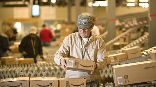 A worker sorts parcels at an Amazon warehouse. The company is set to shed 10,000 jobs from its global workforce.