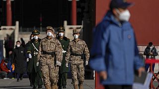 Maszkot viselő katonák a pekingi Tiltott Város területén