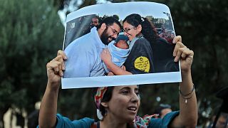 متظاهرة تحمل صورة لعلاء عبد الفتاح وشقيقته منى وولده