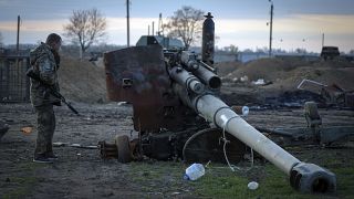 Un soldado ucraniano inspecciona un cañón ruso dañado en el pueblo recientemente retomado Chornobaivka, cerca de Kherson, Ucrania, el martes 15 de noviembre de 2022.