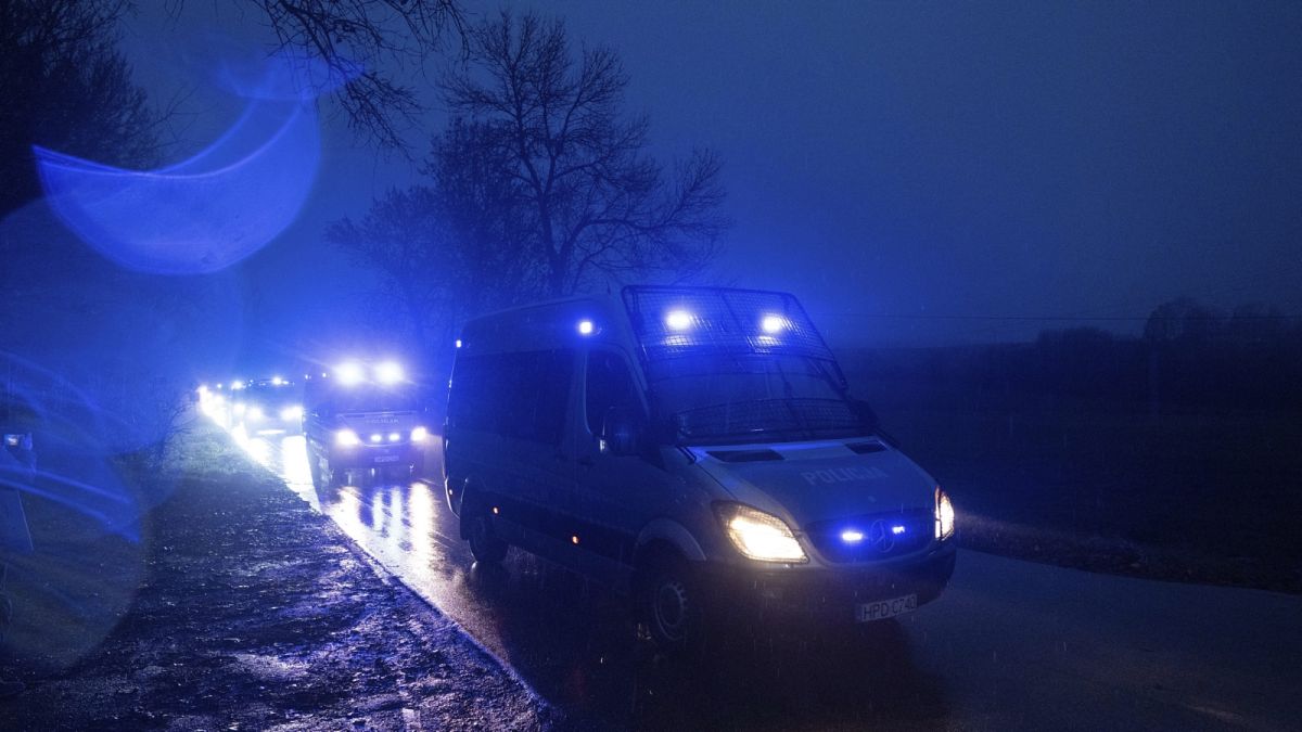 Rendőrautók tartanak a becsapódás helyszínére a lengyelországi Przewodowban