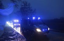 Rendőrautók tartanak a becsapódás helyszínére a lengyelországi Przewodowban