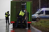 Un agente de policía revisa un vehículo en el exterior de un depósito de grano donde, según el gobierno polaco, la explosión de un misil de fabricación rusa mató a personas.