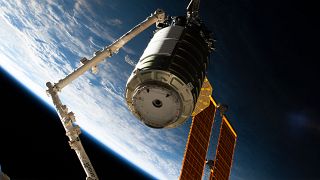 A space freighter in the grip of the International Space Station's Canadarm2 robotic arm