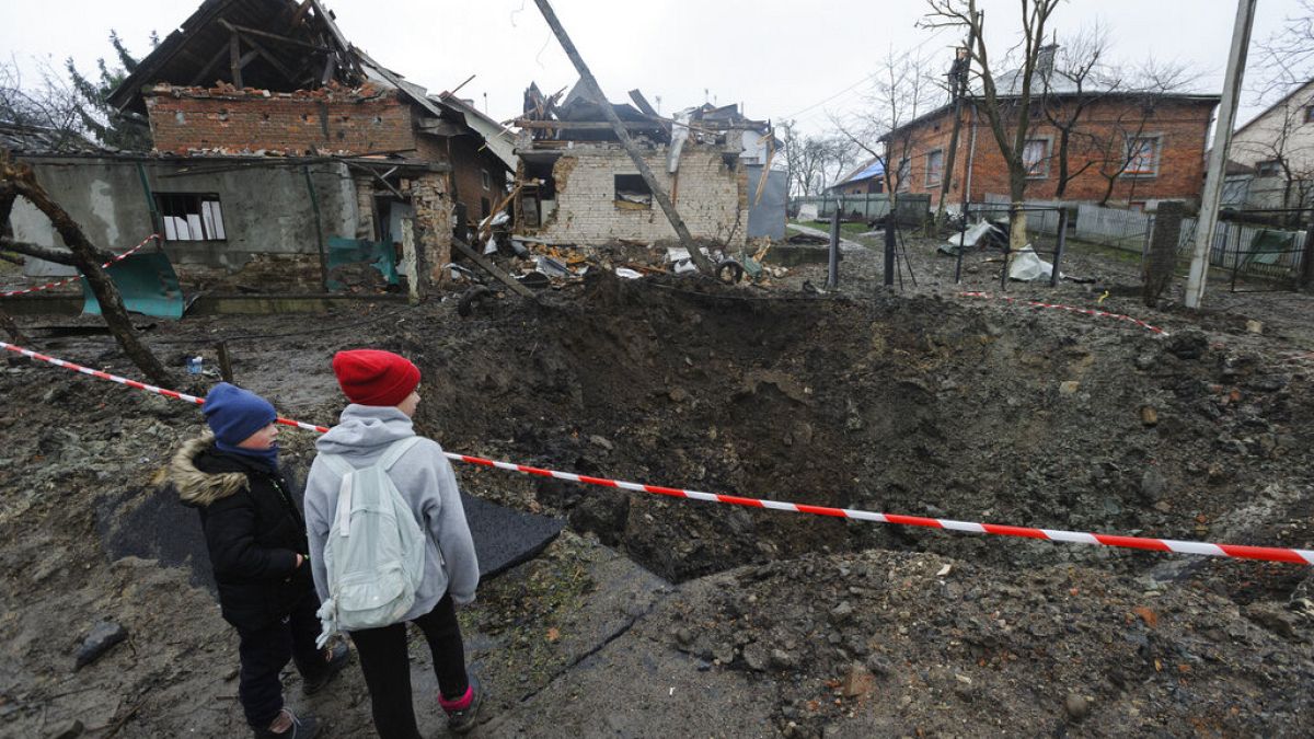 Gyerekek egy bombatölcsérnél a nyugat-ukrajnai Lvivben, 2022 novembere