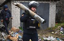 A Ukrainian sapper carries a part of a projectile during a demining operation in a residential area in Lyman, Donetsk region, Ukraine, Wednesday, Nov. 16, 2022.